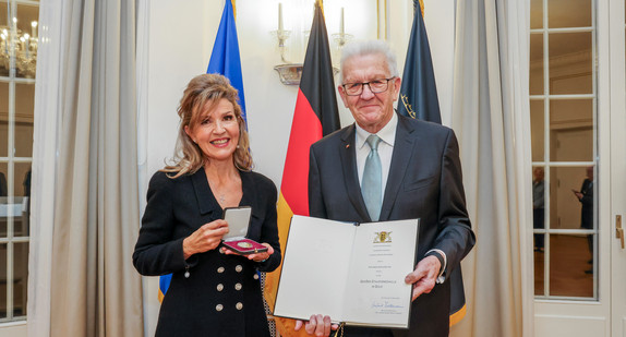 Ministerpräsident Winfried Kretschmann (rechts) und Anne-Sophie Mutter (links) mit der Urkunde und der Staufermedaille in Gold