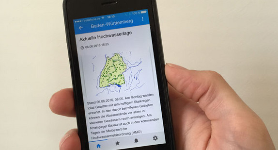 Jemand hält ein Smartphone mit der neuen Wasserstands-App „Meine Pegel“.