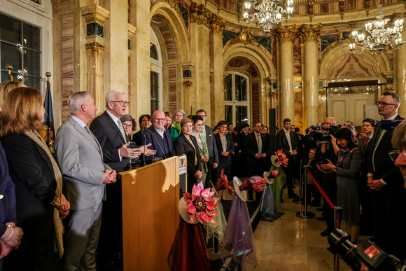 Ministerpräsident Winfried Kretschmann (dritter von links) spricht zu den Gästen, neben ihm stehen seine Ehefrau Gerlinde und die Mitglieder der Landesregierung.