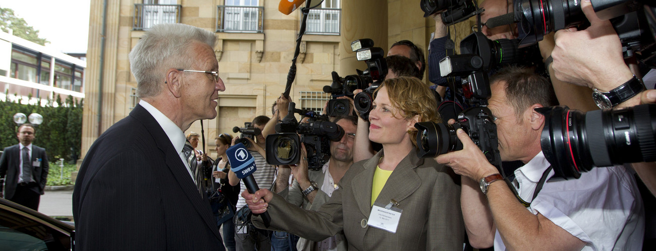 Le ministre-président Winfried Kretschmann avec des journalistes et des photographes devant la Villa Reitzenstein.