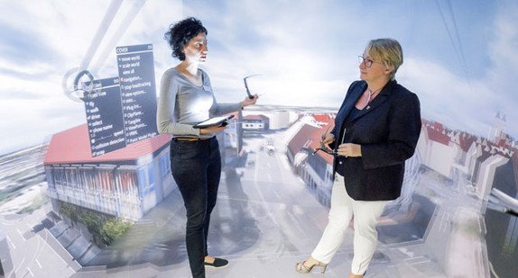 Wissenschaftsministerin Theresia Bauer (r.) steht im Höchsleistungsrechenzentrum Stuttgart in einer vom Supercomputer Hazel Hen generierten virtuellen Umgebung (Bild © Wissenschaftsministerium BW).