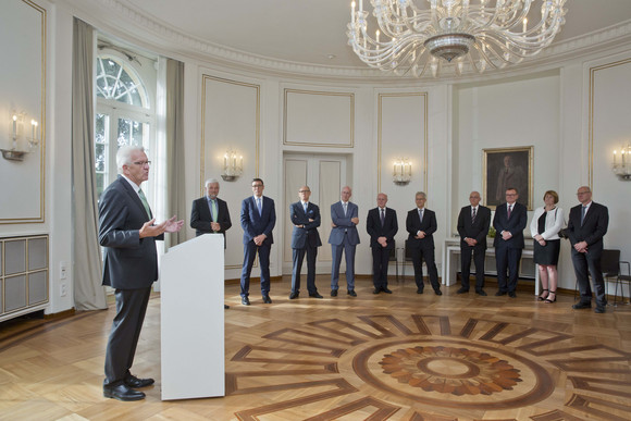 Ministerpräsident Winfried Kretschmann (l.) spricht zu den Präsidentinnen und Präsidenten der Obersten Gerichtshöfe des Bundes