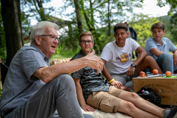 Ministerpräsident Winfried Kretschmann (l.) im Gespräch mit jungen Menschen