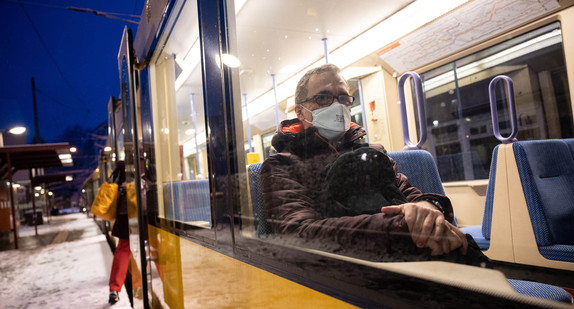 Ein Mann sitzt mit einer FFP2-Maske in einer Bahn.