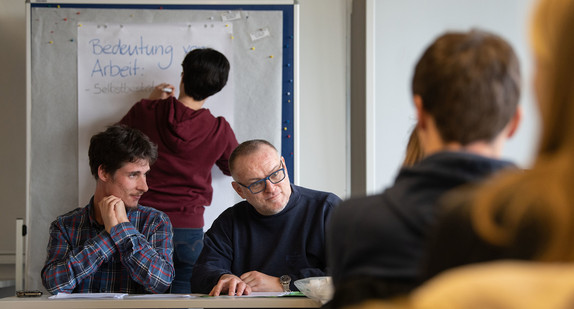 Michael Gänßmantel (l.) und Hartmut Kabelitz (2.v.l), die als geistig behindert gelten, leiten vor Studenten und Studentinnen der Sozialarbeit und Inklusiven Pädagogik und Heilpädagogik ohne Behinderung ein Seminar im Rahmen des Projekts Inklusive Bildung Baden-Württemberg. (Bild: picture alliance/Marijan Murat/dpa)