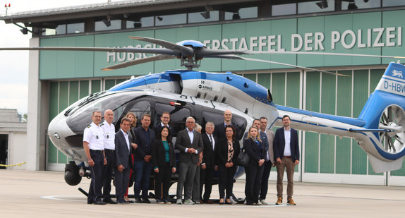 Die Mitglieder des Innenausschusses vor eines Hubschraubers der Polizeihubschrauberstaffel am Flughafen Stuttgart