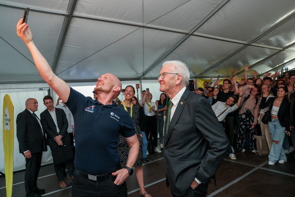 ESA-Astronaut Dr. Alexander Gerst (links) macht ein Selfie mit Ministerpräsident Winfried Kretschmann (rechts) und Studierenden.