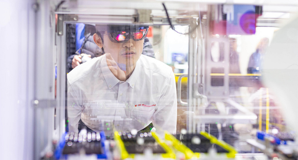 Ein Mitarbeiter von Kawasaki führt bei der Industriemesse Hannover Messe am Messestand von Microsoft die Überwachung und Steuerung einer Maschine mit einer AR-Brille (Augmented Reality) vor.