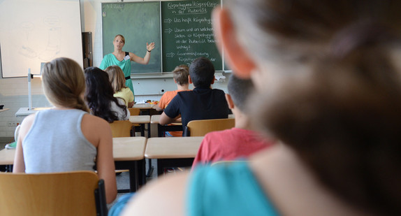 Schülerinnen und Schüler verfolgen den Unterricht bei ihrer Lehrerin. (Bild: dpa)