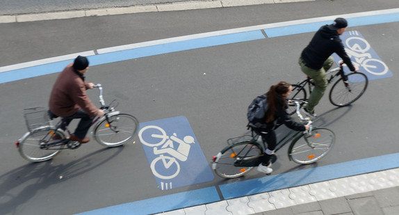 Drei Fahrradfahrer fahren auf einem Radschnellweg.