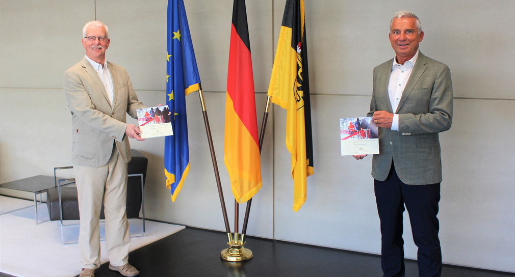 Innenminister Thomas Strobl (r.) mit Klaus Danner (l.), Ombudsperson für die Flüchtlingserstaufnahme in Baden-Württemberg, bei der Übergabe des fünften Tätigkeitsberichts (Bild: Innenministerium Baden-Württemberg)