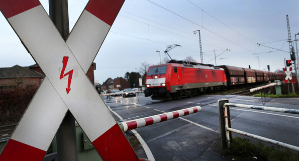 Ein Güterzug fährt über eine Bahnkreuzung (Quelle: dpa).