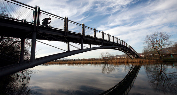 Ein Inlineskater fährt auf einer Fußgängerbrücke.