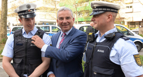 Innenminister Thomas Strobl (M.) betrachtet am 07.04.2017 in Stuttgart zwei mit verschiedenen Body-Cams ausgerüstete Polizisten. (Foto: dpa)