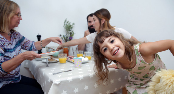 Eine Familie sitzt am Frühstückstisch.