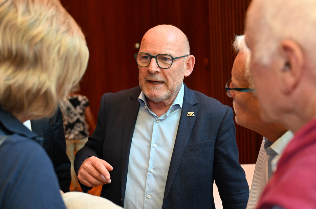 Winfried Hermann (Mitte), Minister für Verkehr, im Gespräch