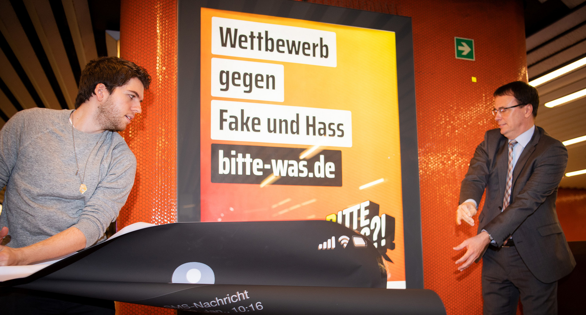 Alexander Straub (l), Botschafter des Projekts #RespektBW, und Staatssekretär Volker Schebesta enthüllen ein Plakat der Kampagne „Bitte Was?! Kontern gegen Fake und Hass“ (Bild: picture alliance/Tom Weller/dpa)