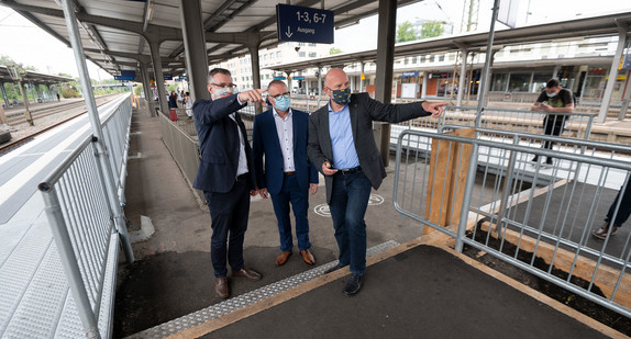 v.l.n.r.: Torsten Krenz (Konzernbevollmächtigter der DB AG für das Land Baden-Württemberg), Michael Groh (Regionalbereichsleiter Südwest der DB Station&Service) und Verkehrsminister Winfried Hermann stehen an einem provisorischen barrierefreien Bahngleis im Bahnhof Göppingen. (Bild: © picture alliance/Marijan Murat/dpa)