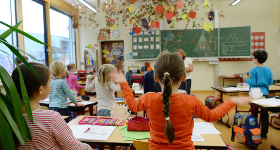 Weißenau: Mehrere Grundschüler singen der Grundschule nach dem Unterricht ein Lied und bewegen dazu ihre Hände. (Foto: © dpa)