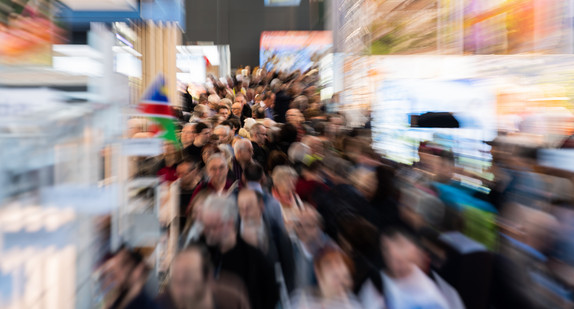 Besucher gehen bei der Reisemesse CMT durch eine Halle der Messe Stuttgart. (Bild: picture alliance/Tom Weller/dpa)