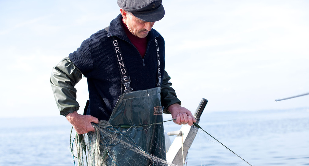 Ein Fischer auf seinem Boot auf dem Bodensee