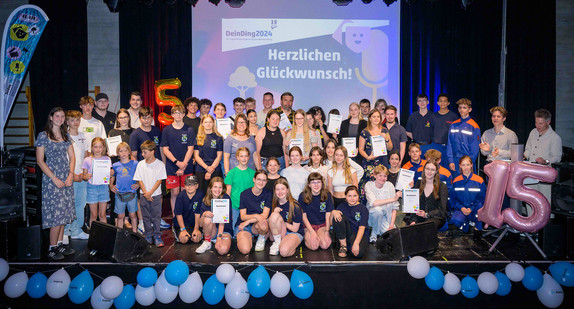 Gruppenfoto aller Preisträger des Jugendbildungspreises DeinDing 2024 auf der Bühne des Stuttgarter Jugendhauses Cann