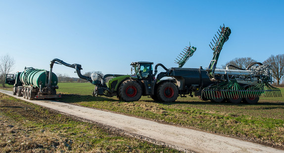 Ein Landwirt betankt sein Gespann mit Gülle um diese anschließend auf einem Feld auszubringen. (Foto: © dpa)