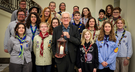 Gruppenbild mit Ministerpräsident Winfried Kretschmann (vorne in der Mitte) mit dem Friedenslicht in den Händen und jugendlichen Pfadfinderinnen und Pfadfindern