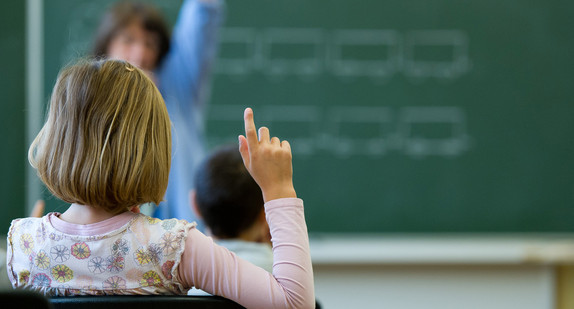 Eine Schülerin meldet sich in einer Schule in Stuttgart während des Unterrichts.