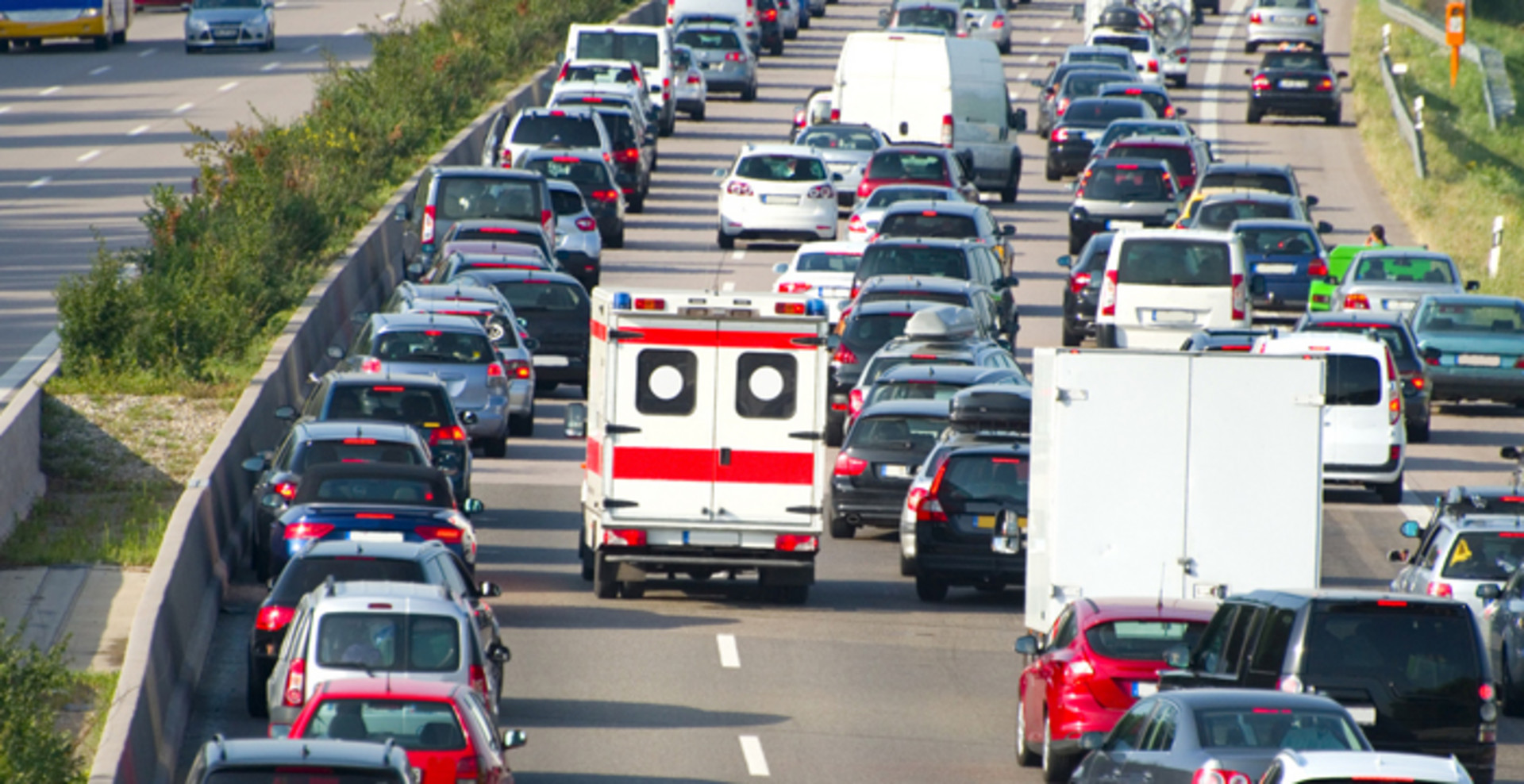 Autos bilden eine Rettungsgasse, die den Weg für einen Rettungswagen frei macht.