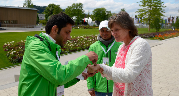 Asylbewerber begrüssen am Zugang zum Gelände der Landesgartenschau 2014 in Schwäbisch-Gmünd eine Besucherin (Bild: © dpa).