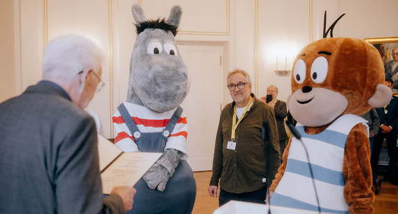 Ministerpräsident Winfried Kretschmann (links) verliest die Urkunde zur Ernennung von Äffle & Pferdle als Dialektbotschafter des Landes.