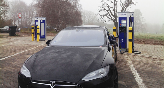 Ein Elektroauto lädt an einer Schnellladesäule an der Autobahn.