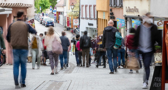 Menschen gehen durch die Fußgängerzone.