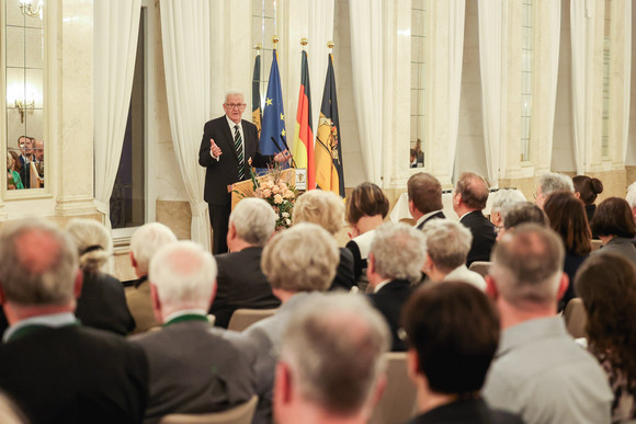 Ministerpräsident Winfried Kretschmann (hinten) bei seiner Ansprache zu den Gästen