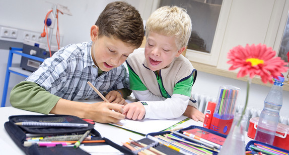 Die Schüler Johannes (l.) und Felix (r.), ein Junge mit Down-Syndrom, sitzen in der Gemeinschaftsschule Gebhardschule in Konstanz an einem Klassentisch beim Malen. (Foto: © dpa)