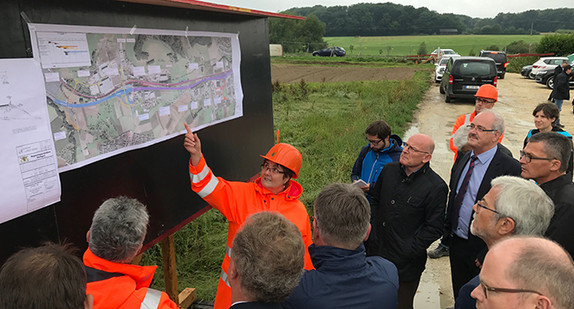 Verkehrsminister Winfried Hermann (7.v.l.) betrachtet gemeinsam mit den Teilnehmern der Baustellentour 2017 ein Plakat mit den Bauvorhaben. (Foto: Ministerium für Verkehr)