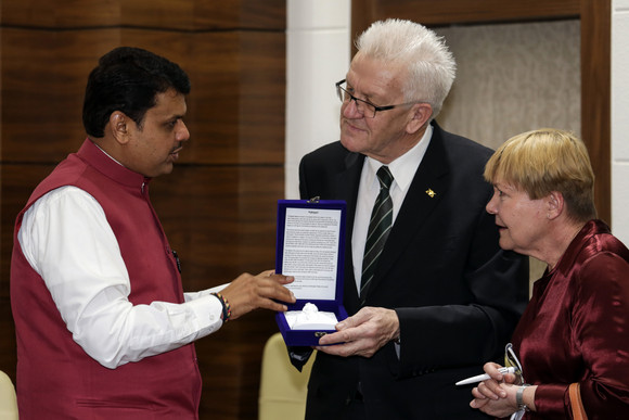 Ministerpräsident Winfried Kretschmann (r.) und der Ministerpräsident von Maharashtra, Chief Minister Devendra Fadnavis (l.) bei der Übergabe eines Gastgeschenks