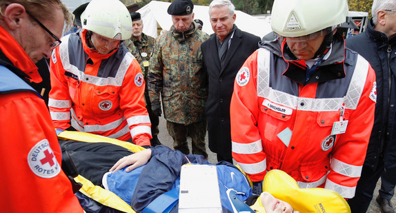 Innenminister Thomas Strobl und Brigadegeneral Andreas Henne schauen sich an, wie die Verletzten bei der Übung versorgt werden. (Bild: Leif Piechowski / Lichtgut)