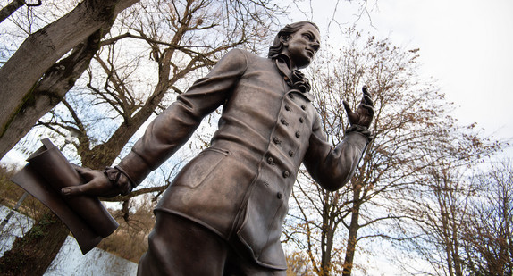 Eine Skulptur des Künstlers Waldemar Schröder, die Friedrich Hölderlin darstellt, steht vor Bäumen. (Bild: picture alliance/Marijan Murat/dpa)