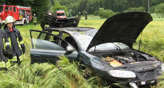 Feuerwehrleute stehen am 11.07.2009 nach einem Unfall bei Schelklingen (Alb-Donau-Kreis) neben dem Wrack eines Autos.  Ein privates Autorennen zweier junger Männer in Baden-Württemberg ist in einer Tragödie geendet. Bild: Uwe Köhle dpa/lsw