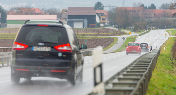 Ein Auto fährt auf einer Landstraße bei Regen.