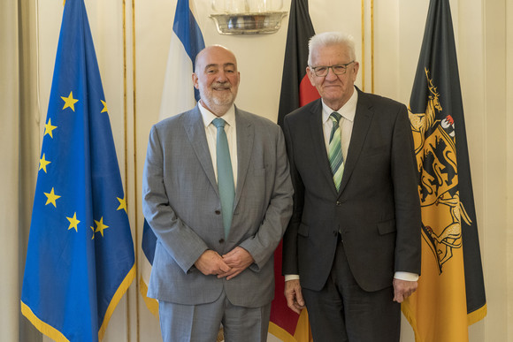 Ministerpräsident Winfried Kretschmann (rechts) und der israelische Botschafter Ron Prosor (links) stehen in der Villa Reitzenstein vor Fahnen.