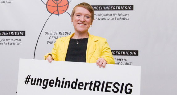 Simone Fischer hält Schild mit Aufdruck #ungehindertRIESIG