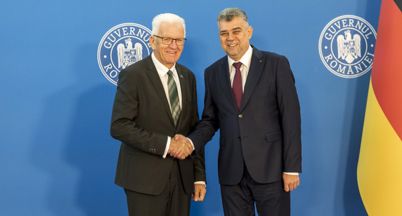 Ministerpräsident Winfried Kretschmann (links) und Rumäniens Premierminister Ion-Marcel Ciolacu (rechts) geben sich die Hand.