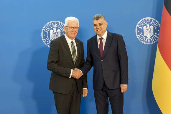 Ministerpräsident Winfried Kretschmann (links) und Rumäniens Premierminister Ion-Marcel Ciolacu (rechts) geben sich die Hand.