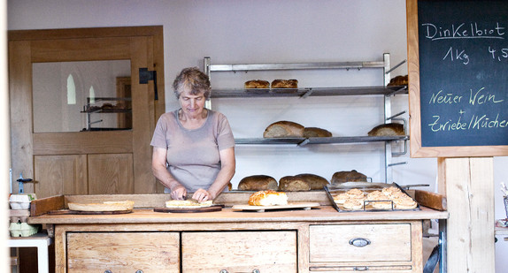 Ein Verkäuferin verkauft Backwaren in einer Bäckerei