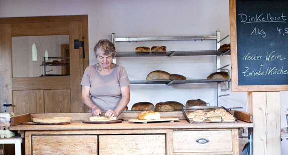 Ein Verkäuferin verkauft Backwaren in einer Bäckerei