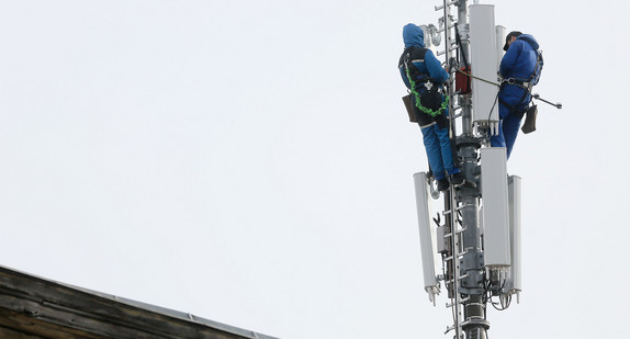 In luftiger Höhe werden Arbeiten an einem Mobilfunkmast vorgenommen.