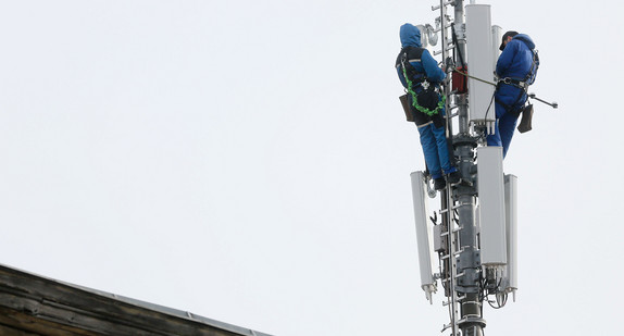 In luftiger Höhe werden Arbeiten an einem Mobilfunkmast vorgenommen.